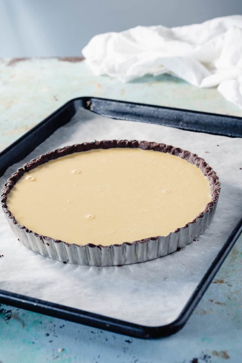 Unbaked banana custard tart on a baking sheet