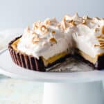 Banana Custard Tart with Meringue on a cake stand with a slice removed