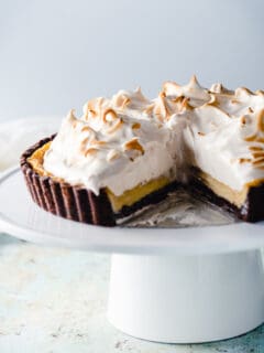 Banana Custard Tart with Meringue on a cake stand with a slice removed