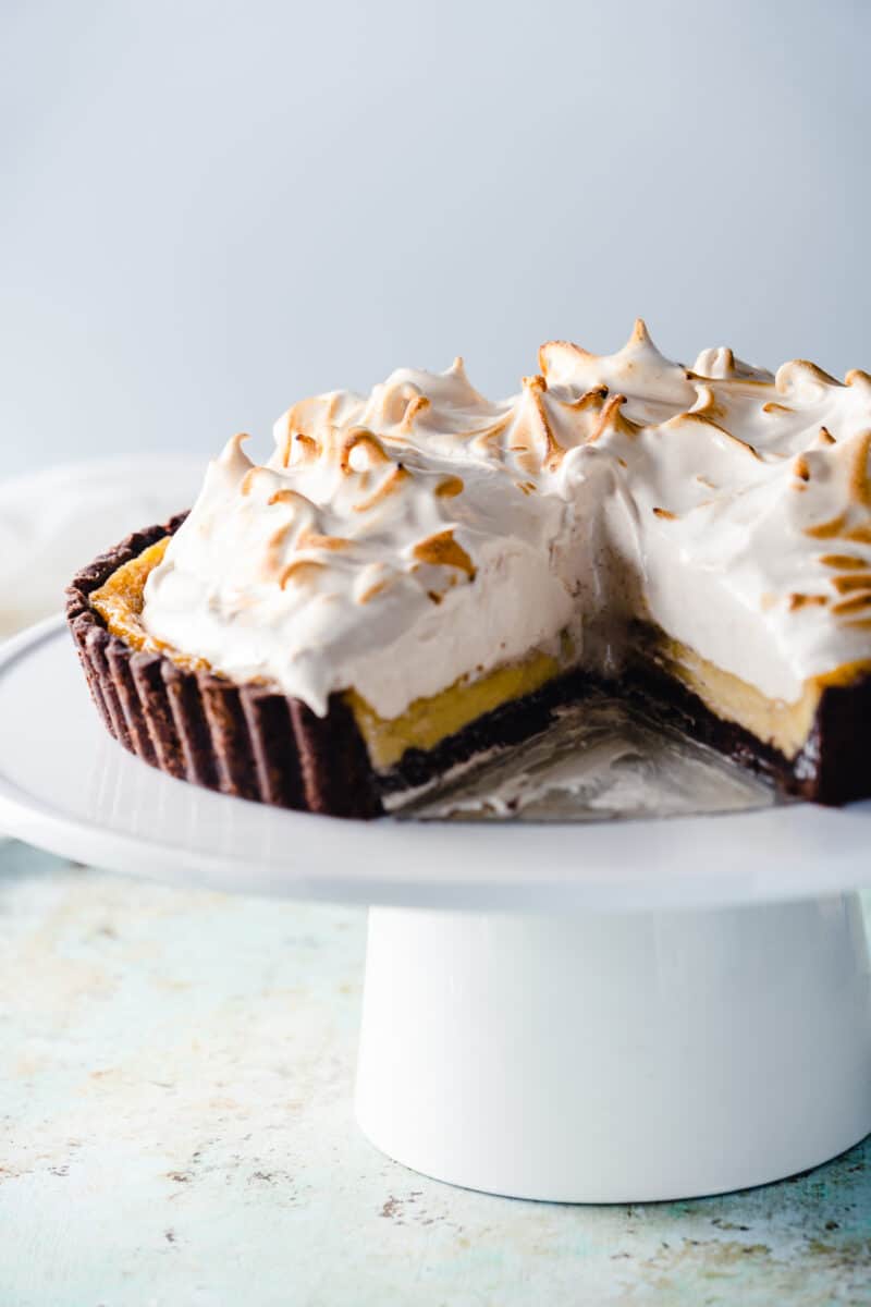 Banana Custard Tart with Meringue on a cake stand with a slice removed