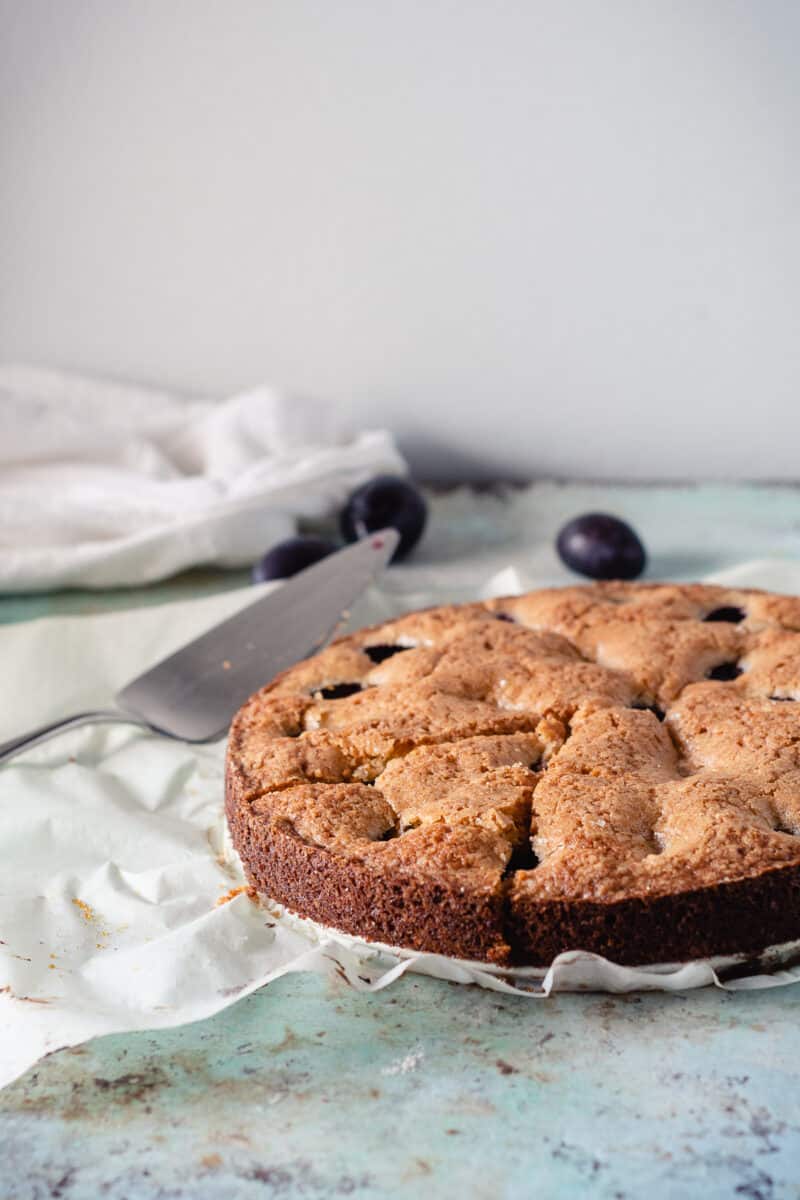 Almond Anise Plum Torte on parchment paper, side view