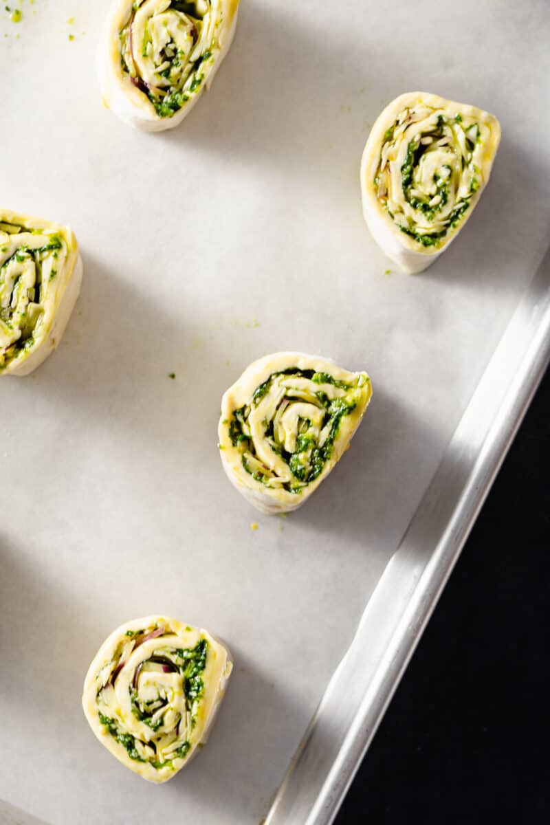 Bombay rolls on a parchment lined sheet pan waiting to go into the oven