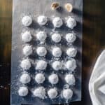 Mexican Wedding Cookies lined up on a sheet of wax paper