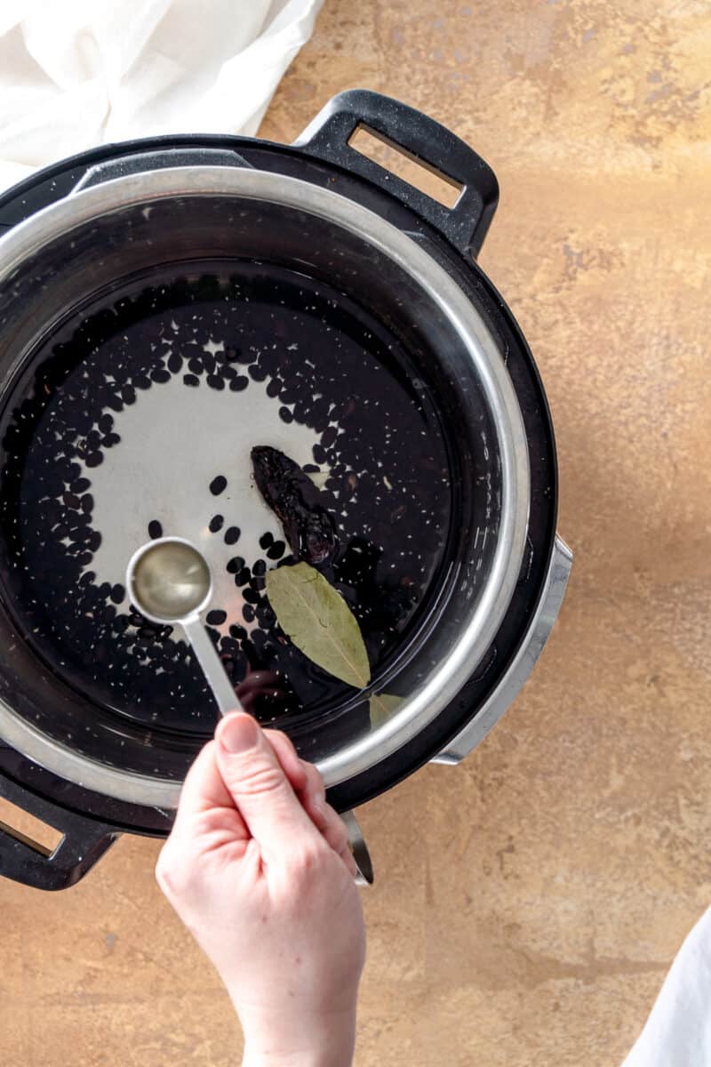 Oil going into an instant pot with black beans