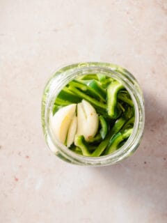 Quick pickled poblano peppers in a mason jar overhead view