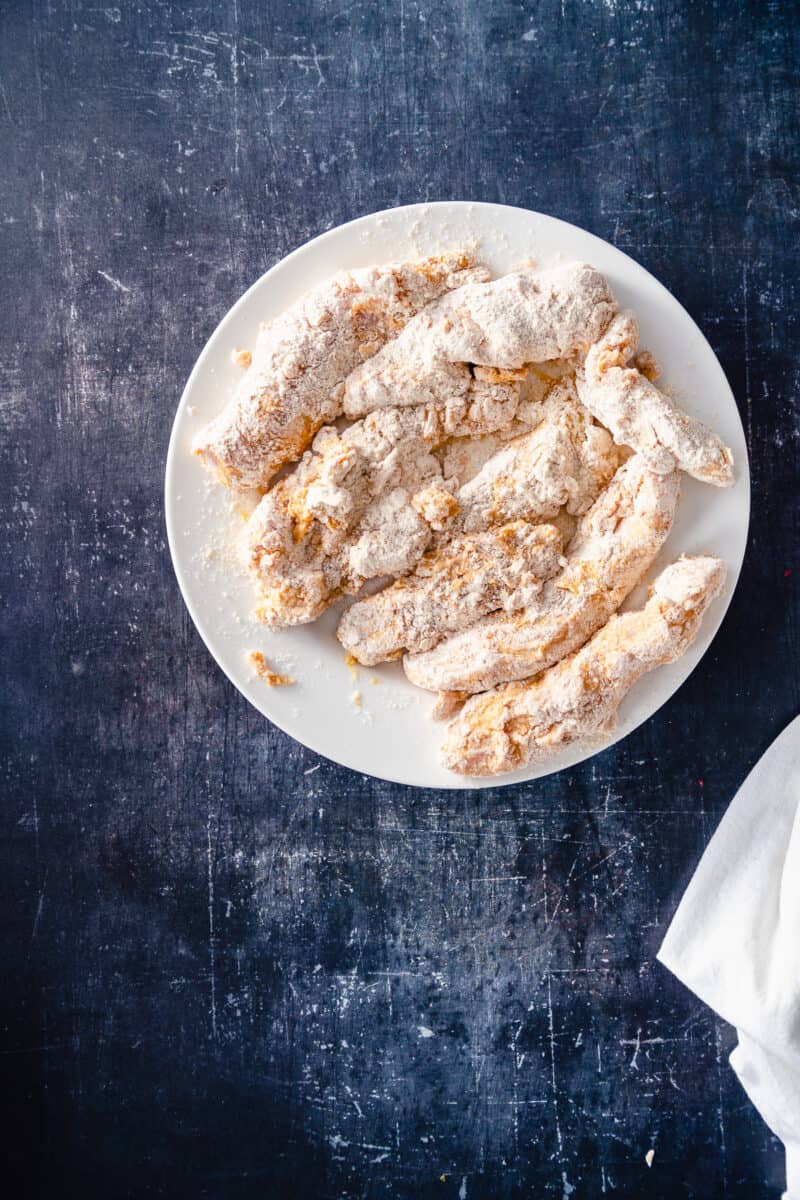 Breaded strips of chicken waiting to be fried