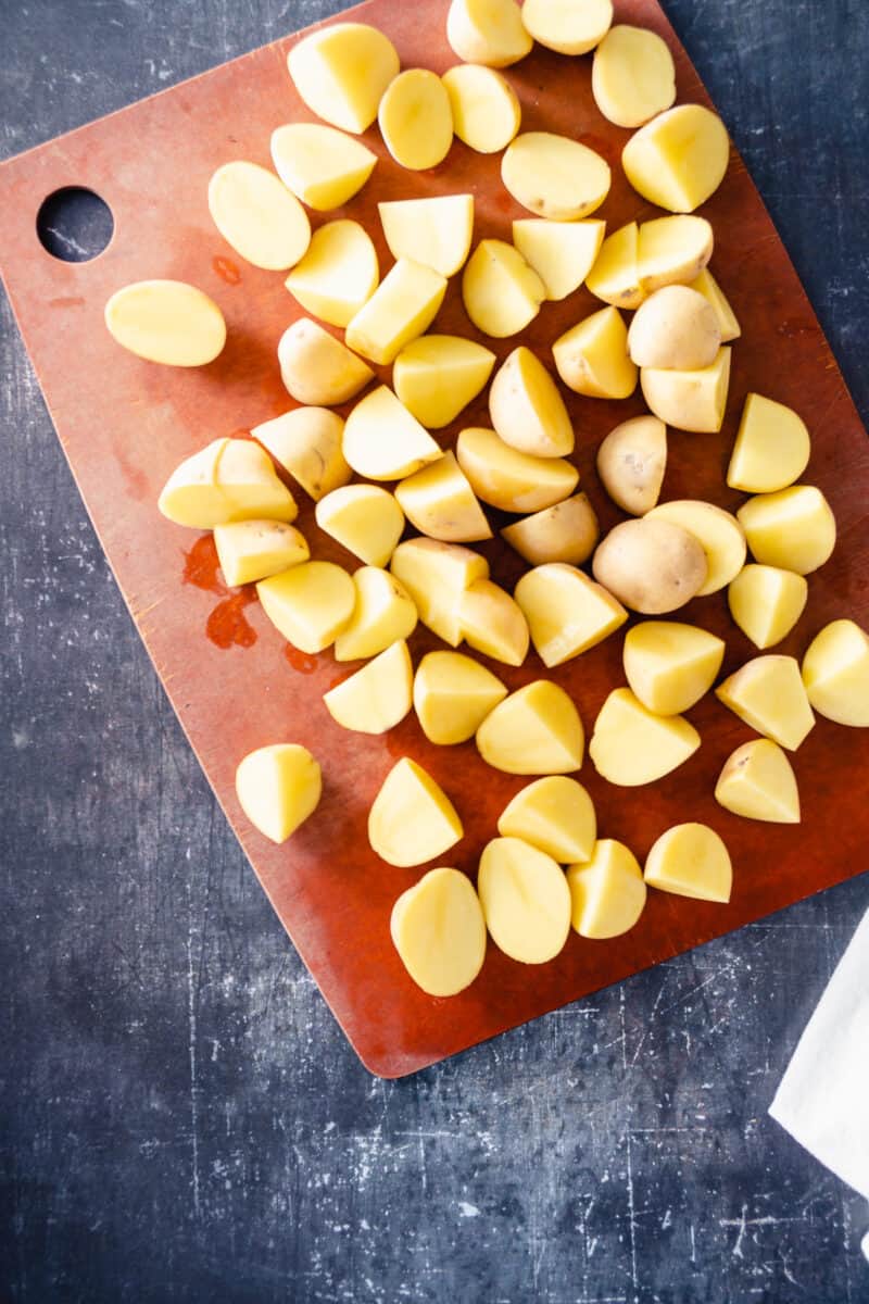 Sliced Yukon gold potatoes on a cutting board