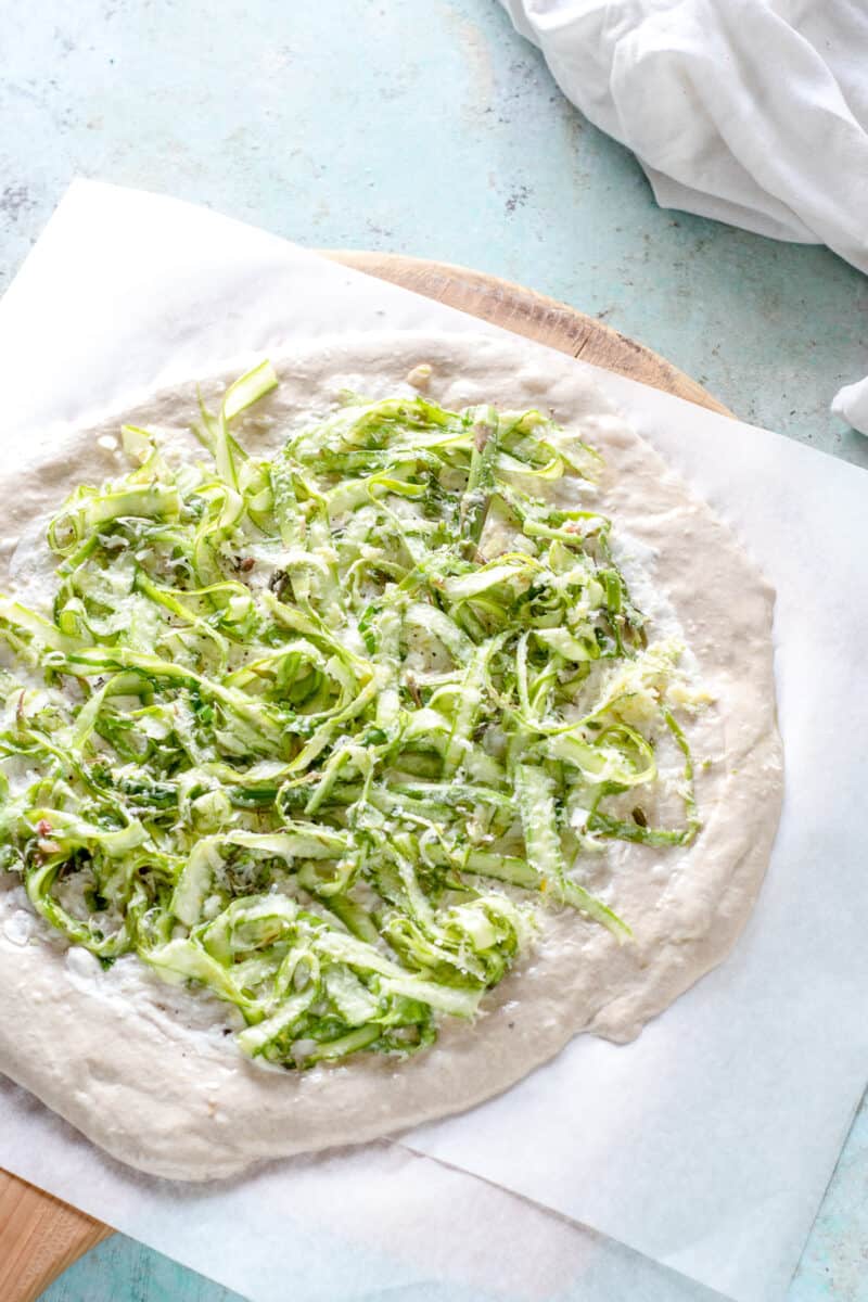 Shaved asparagus on pizza dough