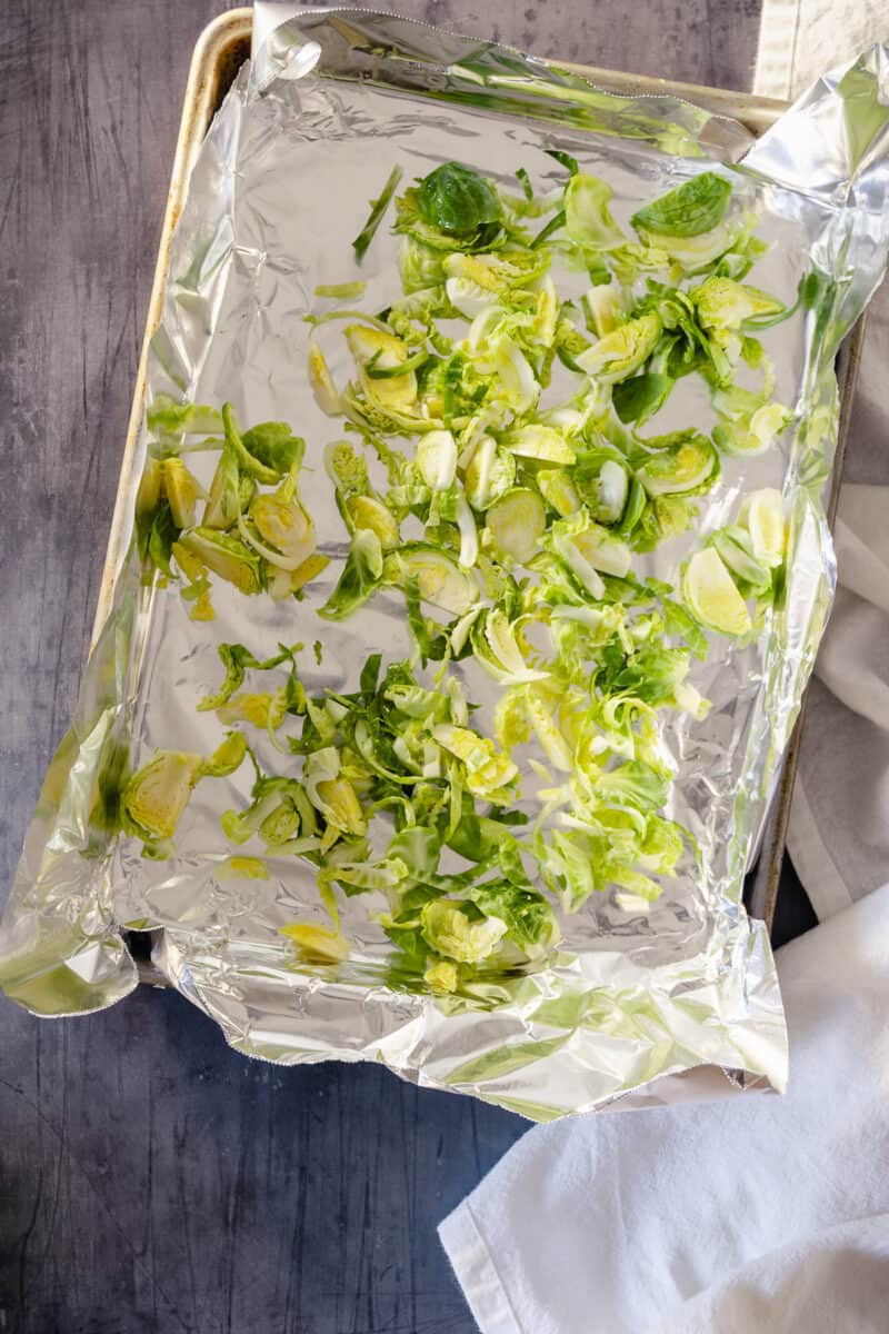 Sliced Brussels sprouts on a foil-lined sheet pan