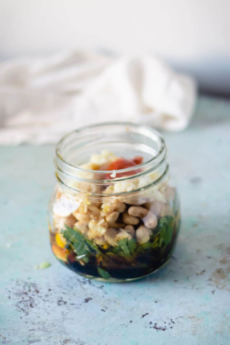 Jar with sriracha, garlic, cashews, lime juice