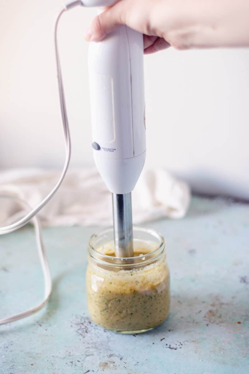 Immersion blending garlicky cashew sauce in a jar