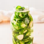 Pickled sliced jalapeños in a mason jar