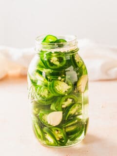 Pickled sliced jalapeños in a mason jar