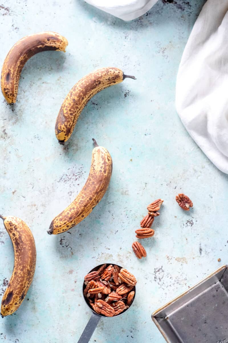 Ripe Bananas, pecans, and an empty loaf pan