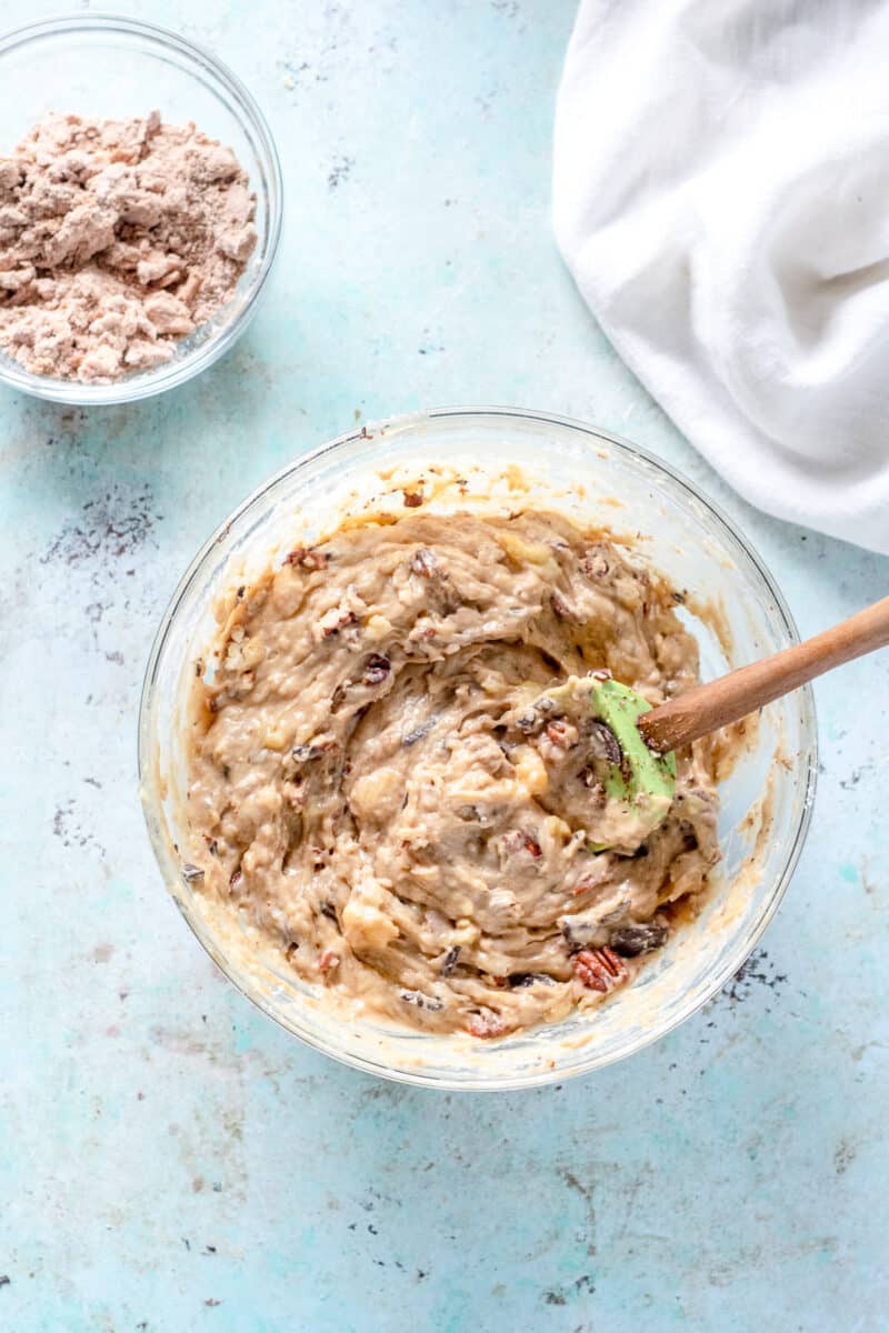 Chocolate and pecan banana bread batter in a mixing bowl with streusel topping in a separate bowl