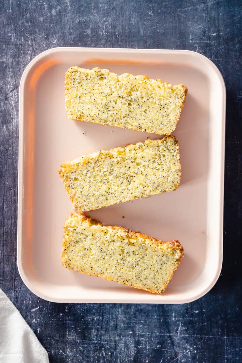 Three Slices of Lemon poppy seed loaf cake on a tray