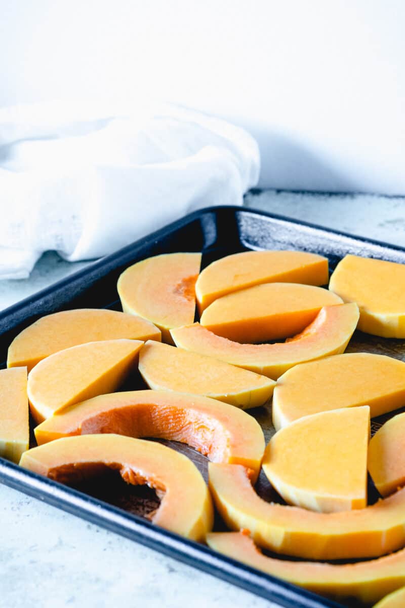 Slices of butternut squash on a baking sheet