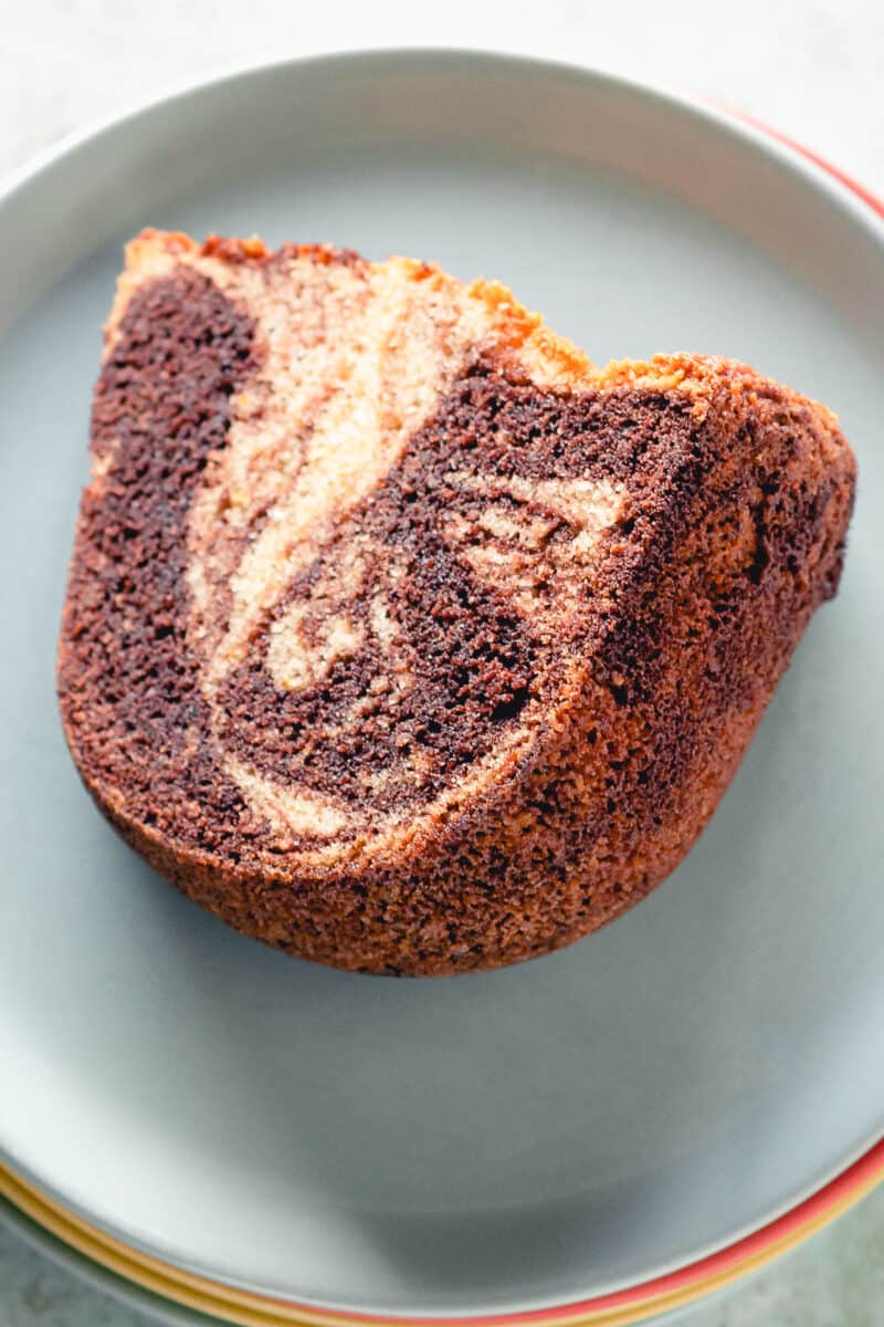 Slice of chocolate orange olive oil bundt cake on a blue plate